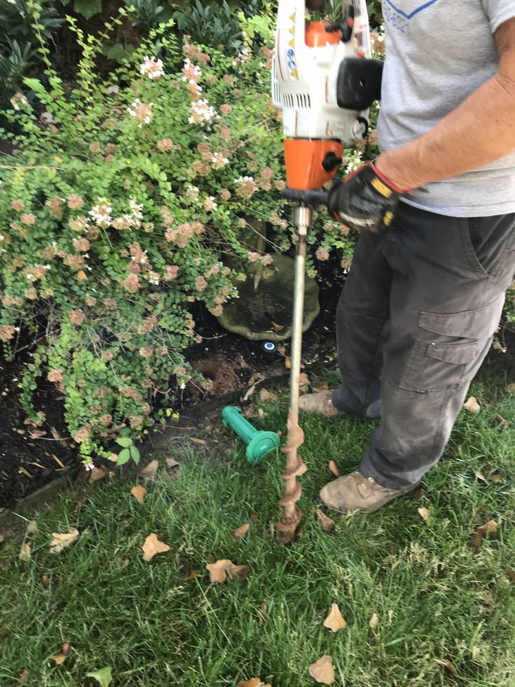 An Acenitec technician drilling a Sentricon termite station hole with an earth auger